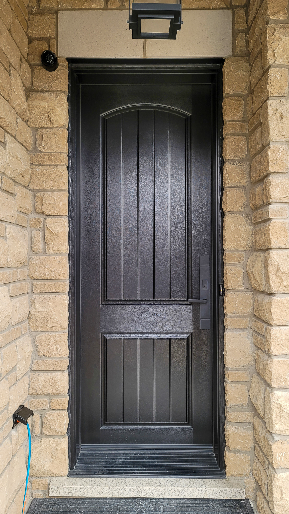 Two-panel arched top fiberglass door with plank detail
