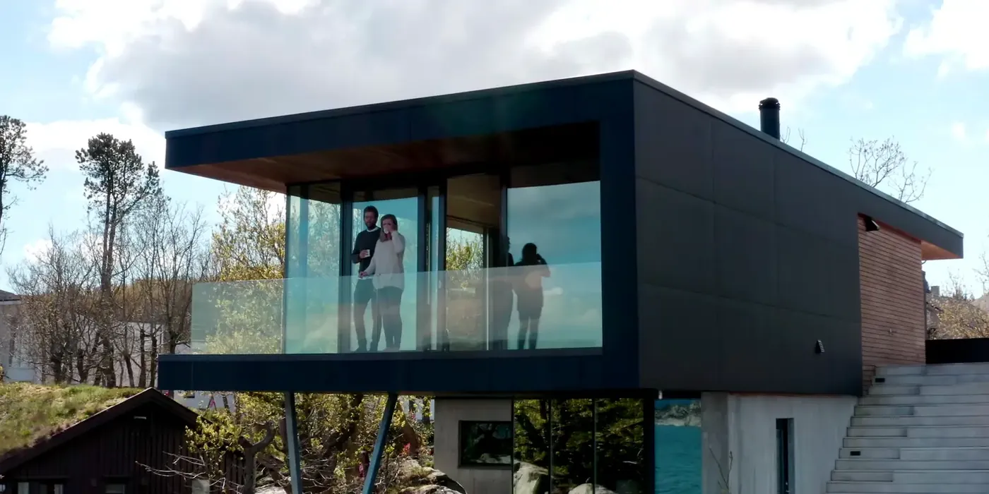 Hillside house with walls of sliding glass