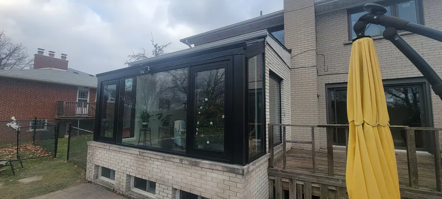 Black aluminum glass sunroom on a brick home