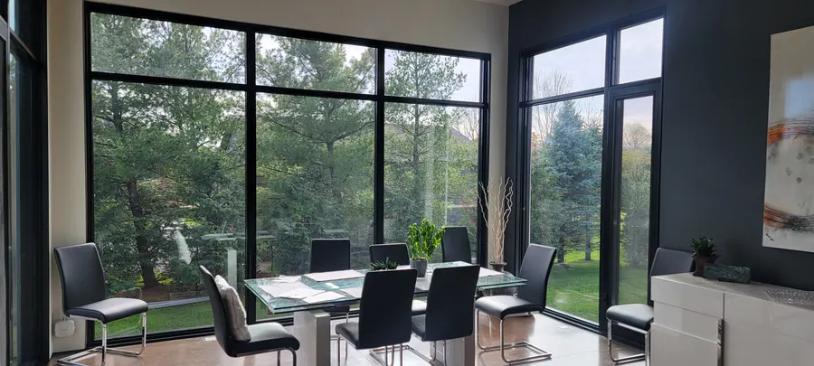 Floor-to-ceiling black aluminum window wall in a dining room