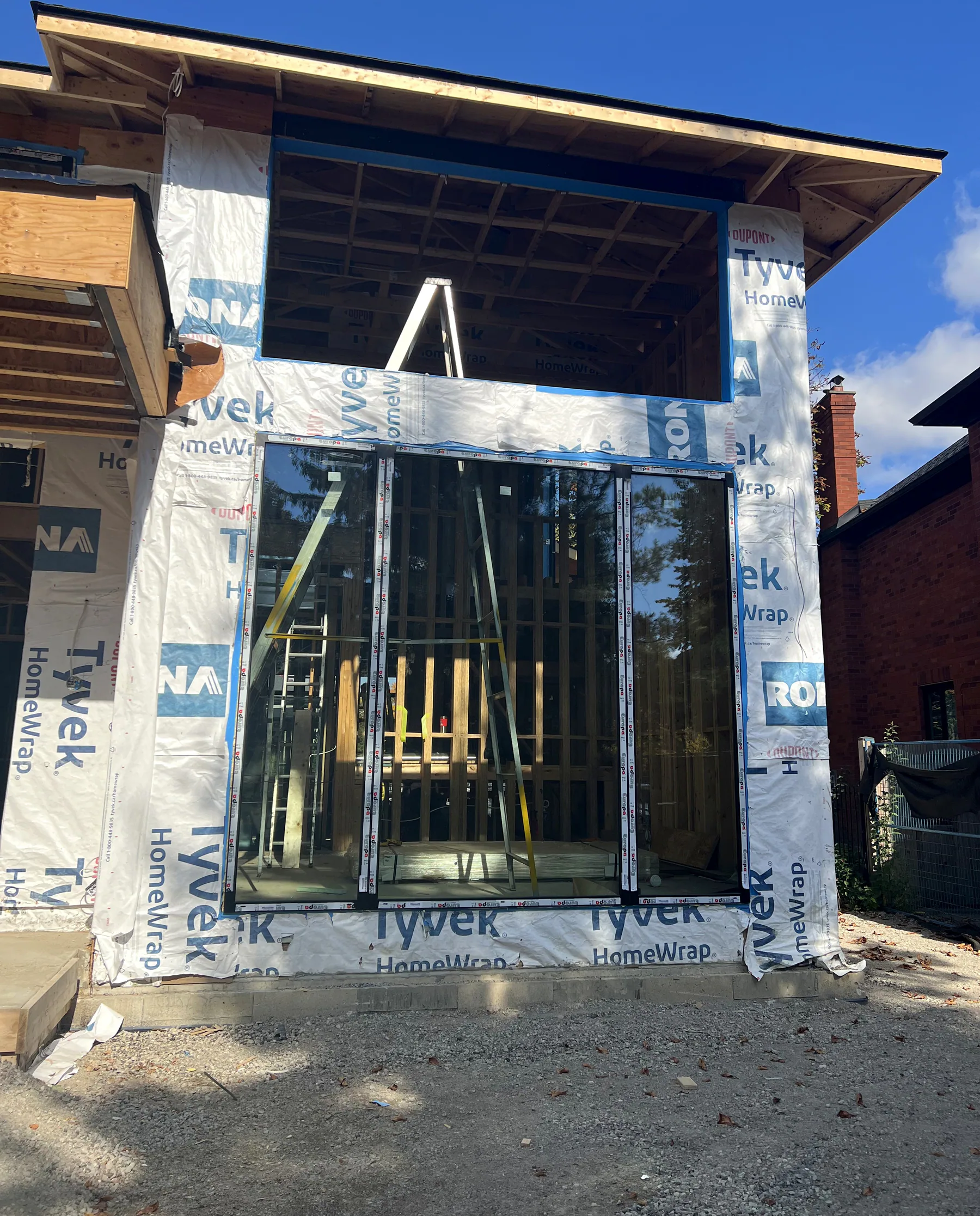 Floor-to-ceiling black aluminum glazing installed on a two-storey wall of a new build