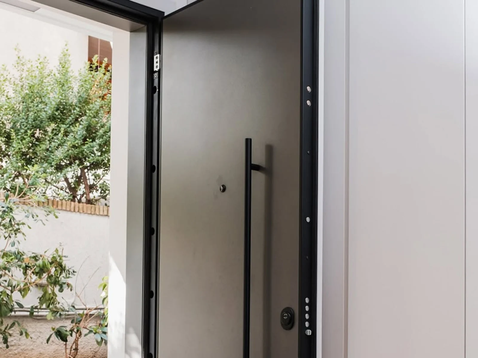 Open modern security door showing reinforced frame and hardware points